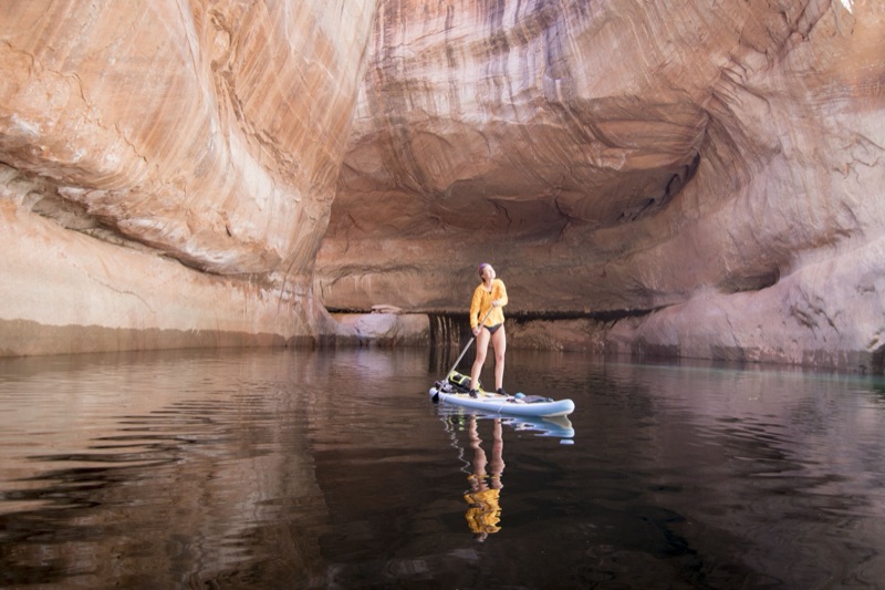 Paddleboarder in a sandstone amphitheater on glassy water, Lake Powell