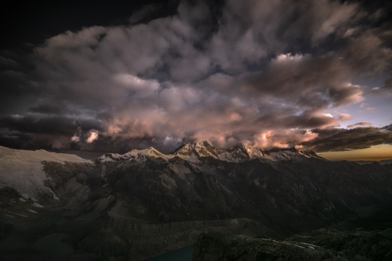 Storm clouds catching last light over a high mountain range