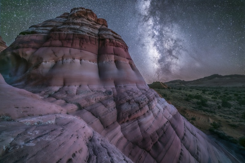 Milky Way rising over banded sandstone domes at night