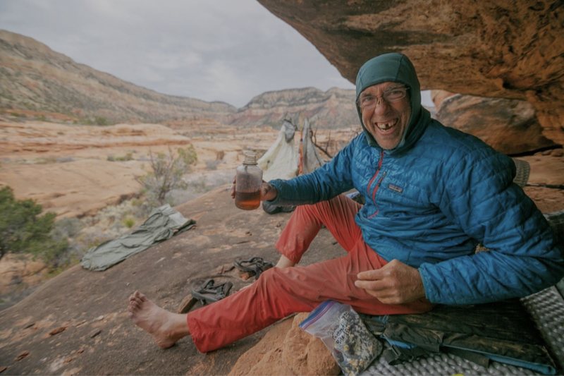 Paul Gagner raising a bottle of camp tea under a sandstone alcove, Cedar Mesa country - the frame Patagonia ran as a full-page ad in the Sunday New York Times (2024)
